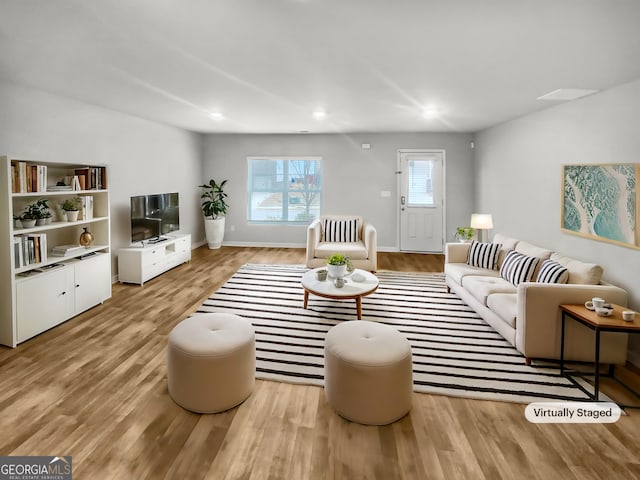 living area with baseboards, light wood-type flooring, and recessed lighting