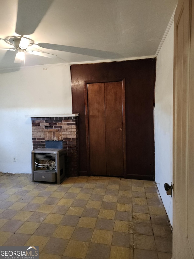 1121 Carroll St, Macon, GA 31206 - unfurnished living room featuring a wood stove, ceiling fan, and crown molding