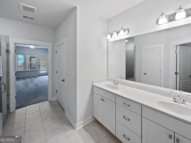 bathroom with double vanity, visible vents, and a sink