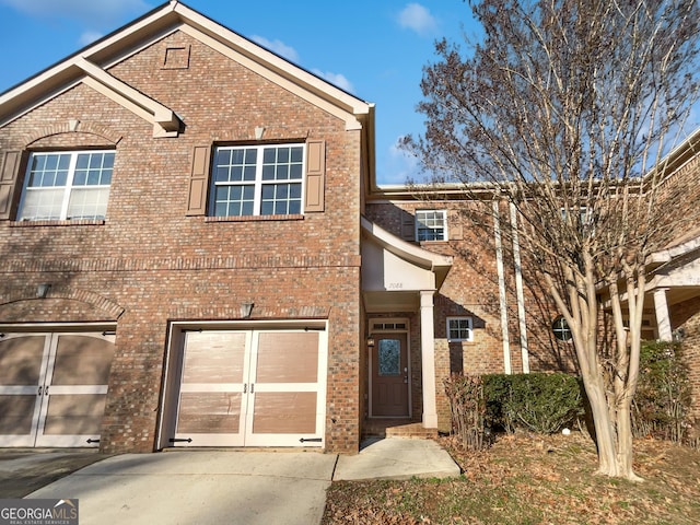 traditional-style home with brick siding, driveway, and an attached garage