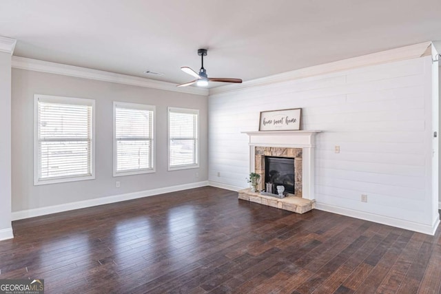 unfurnished living room with dark hardwood / wood-style flooring, a stone fireplace, and ornamental molding