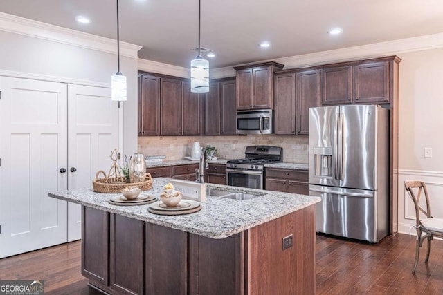 kitchen with hanging light fixtures, stainless steel appliances, light stone counters, and dark brown cabinets