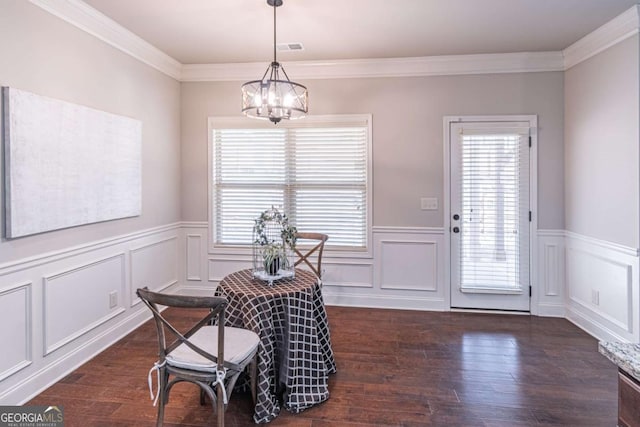 dining space with crown molding, dark hardwood / wood-style floors, and an inviting chandelier