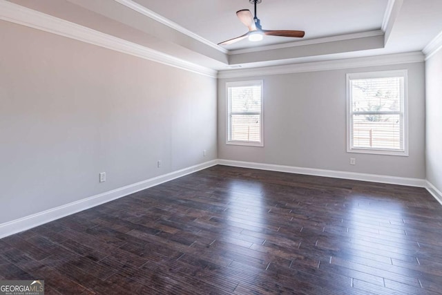 unfurnished room featuring dark hardwood / wood-style flooring, ceiling fan, a raised ceiling, and ornamental molding