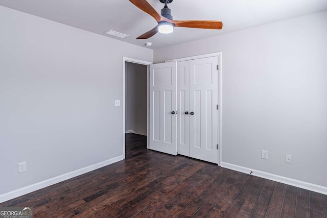 unfurnished bedroom featuring ceiling fan, a closet, and dark hardwood / wood-style flooring