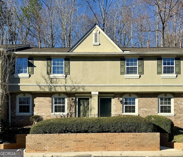 townhome / multi-family property with brick siding and stucco siding