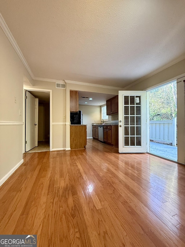 6900 Roswell Rd Unit 7N, Atlanta, GA 30328 - unfurnished living room with a textured ceiling, light wood-type flooring, visible vents, and a healthy amount of sunlight