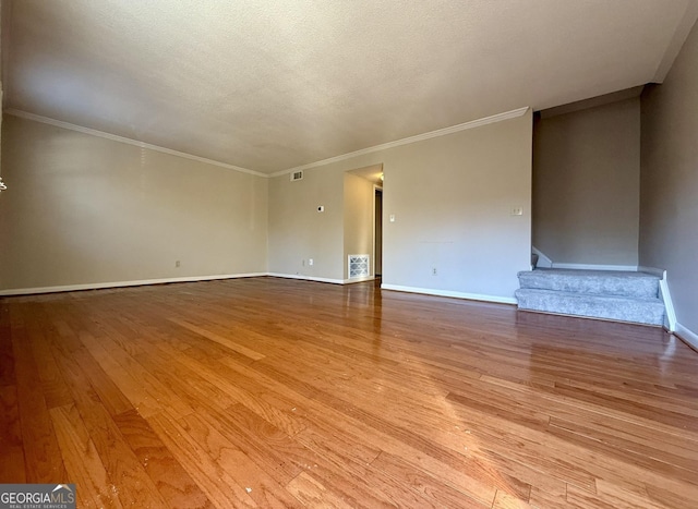 6900 Roswell Rd Unit 7N, Atlanta, GA 30328 - unfurnished living room with baseboards, visible vents, light wood-style flooring, stairs, and a textured ceiling