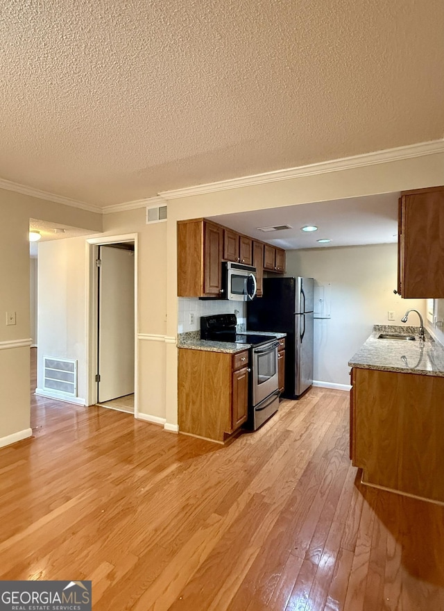 6900 Roswell Rd Unit 7N, Atlanta, GA 30328 - kitchen featuring stainless steel appliances, light wood-style floors, visible vents, and a sink
