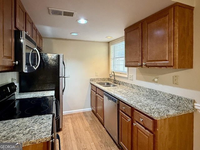 6900 Roswell Rd Unit 7N, Atlanta, GA 30328 - kitchen featuring light stone counters, stainless steel appliances, visible vents, brown cabinetry, and a sink