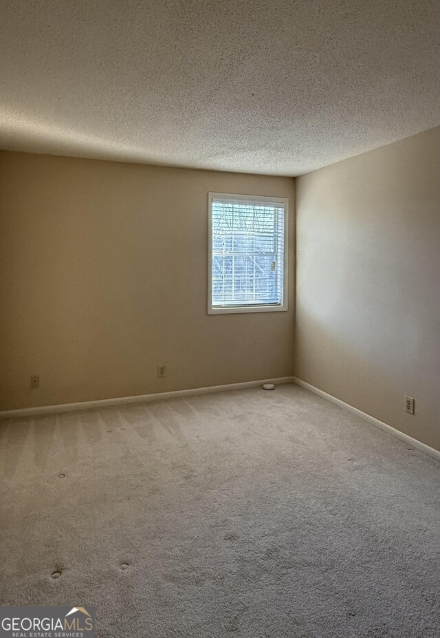 6900 Roswell Rd Unit 7N, Atlanta, GA 30328 - carpeted empty room featuring a textured ceiling and baseboards