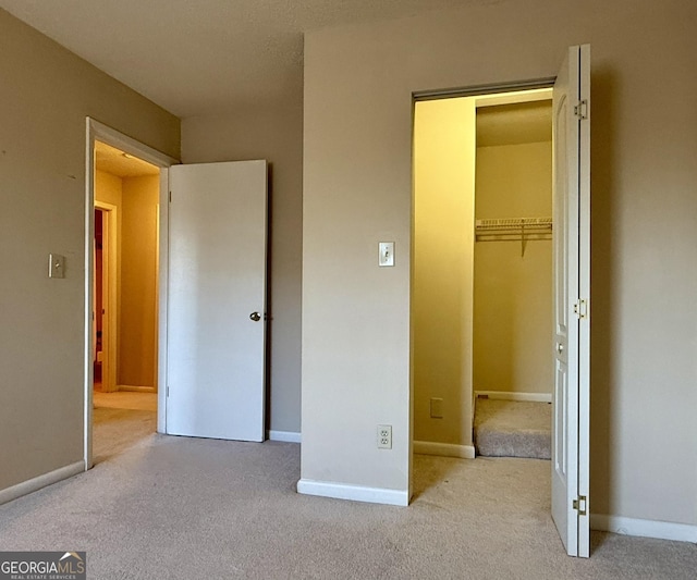 6900 Roswell Rd Unit 7N, Atlanta, GA 30328 - unfurnished bedroom with light carpet, a spacious closet, and baseboards