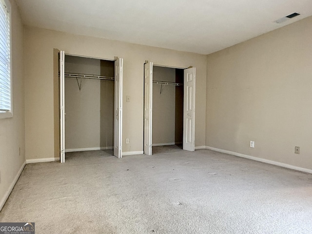 6900 Roswell Rd Unit 7N, Atlanta, GA 30328 - unfurnished bedroom with multiple closets, visible vents, and baseboards