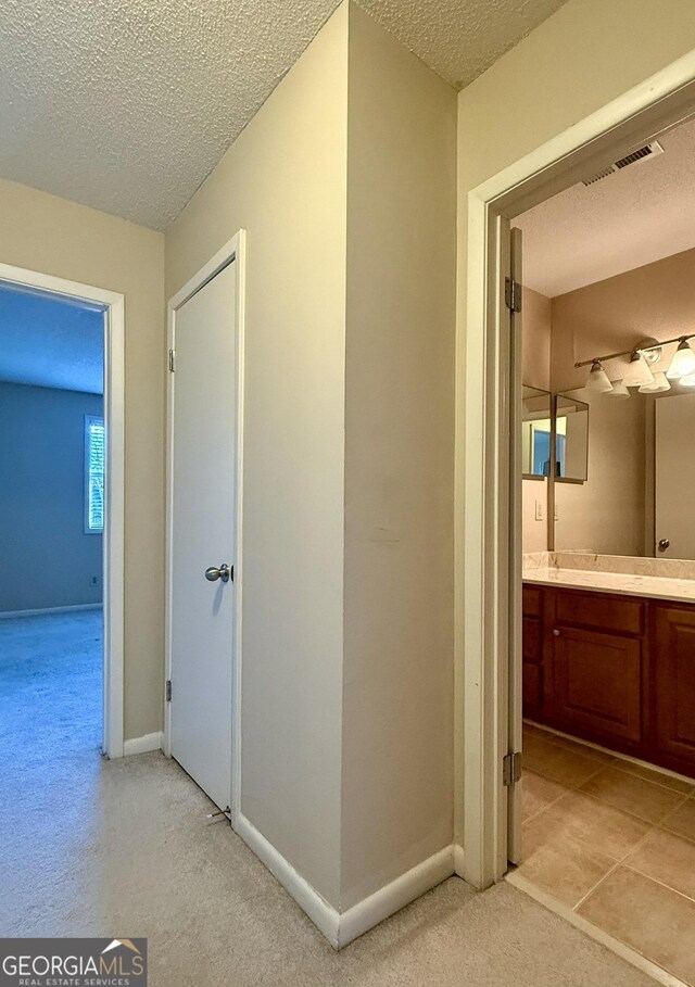 6900 Roswell Rd Unit 7N, Atlanta, GA 30328 - hallway with visible vents, a textured ceiling, and baseboards