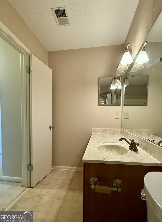 6900 Roswell Rd Unit 7N, Atlanta, GA 30328 - bathroom with a textured ceiling, tile patterned flooring, vanity, visible vents, and baseboards