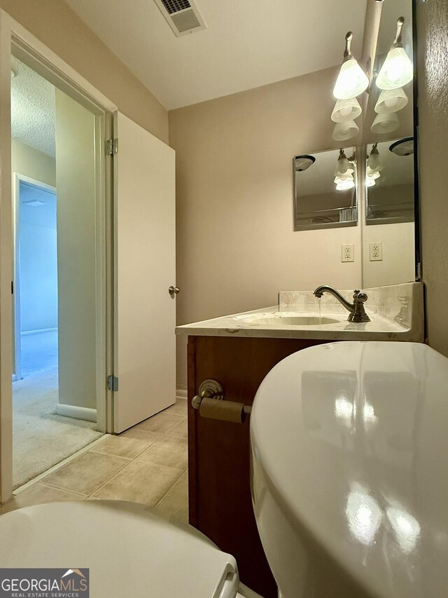 6900 Roswell Rd Unit 7N, Atlanta, GA 30328 - bathroom featuring visible vents, an inviting chandelier, a textured ceiling, vanity, and tile patterned floors