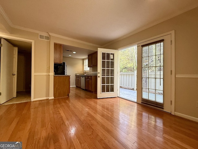 6900 Roswell Rd Unit 7N, Atlanta, GA 30328 - unfurnished living room featuring ornamental molding, baseboards, visible vents, and light wood finished floors