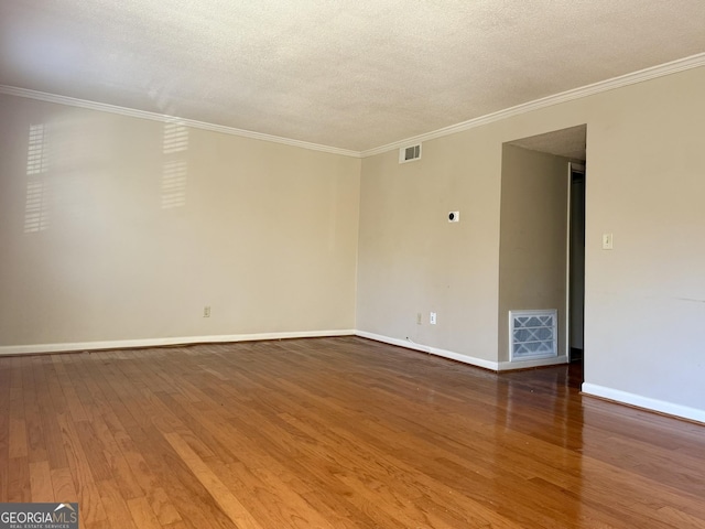 6900 Roswell Rd Unit 7N, Atlanta, GA 30328 - spare room with a textured ceiling, wood finished floors, visible vents, baseboards, and crown molding