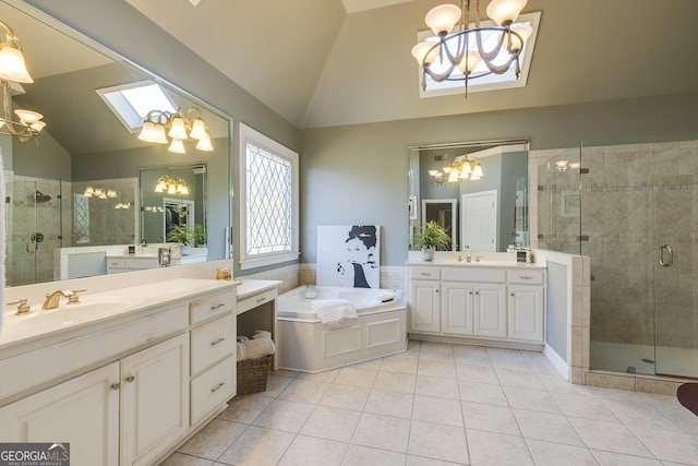 bathroom with vaulted ceiling with skylight, tile patterned flooring, a sink, and an inviting chandelier