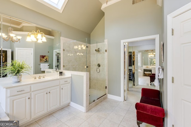 bathroom with lofted ceiling with skylight, a shower stall, vanity, a chandelier, and tile patterned floors