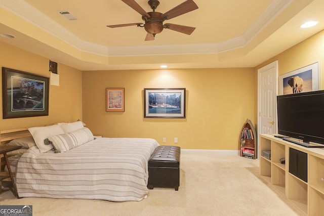 bedroom with visible vents, a raised ceiling, crown molding, and light colored carpet