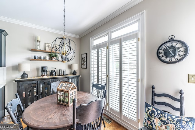 dining area with crown molding, wood finished floors, and a notable chandelier