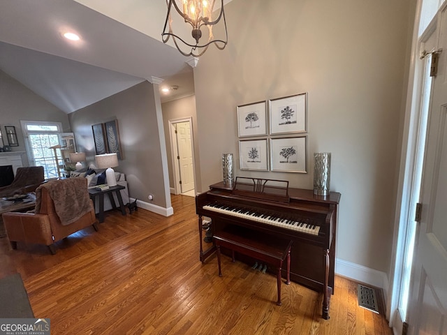 sitting room with baseboards, wood finished floors, visible vents, and a notable chandelier