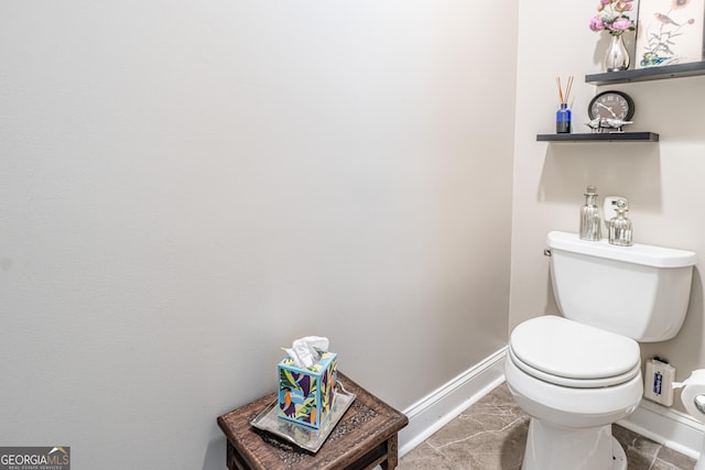 bathroom with baseboards and toilet