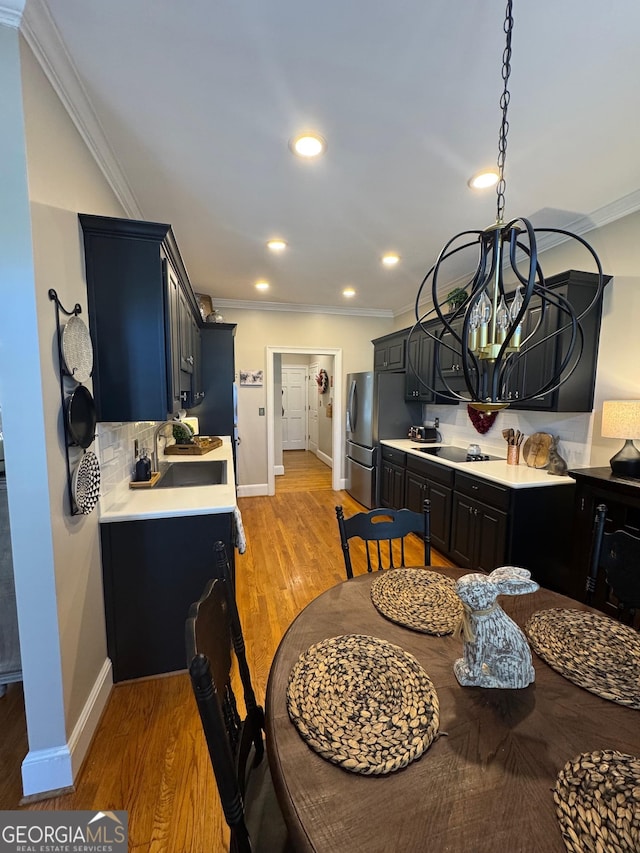 dining area with light wood-style floors, baseboards, crown molding, and recessed lighting