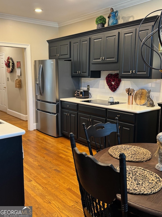 kitchen featuring light wood-style floors, ornamental molding, decorative backsplash, and stainless steel fridge with ice dispenser