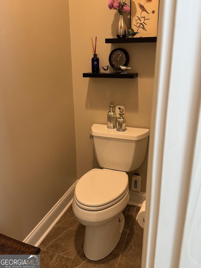 bathroom featuring toilet and baseboards