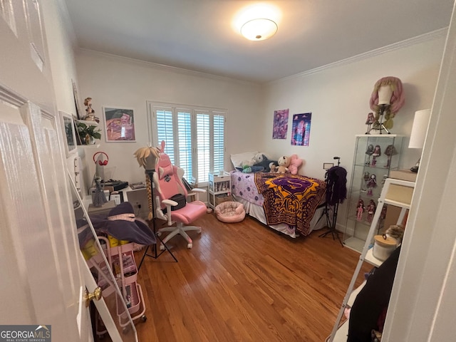 bedroom with crown molding and wood finished floors