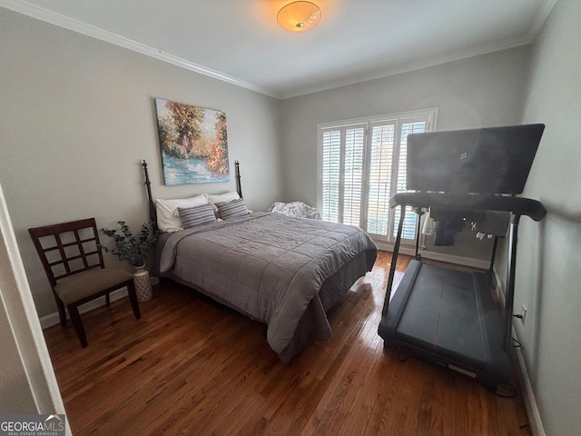 bedroom with baseboards, ornamental molding, and wood finished floors