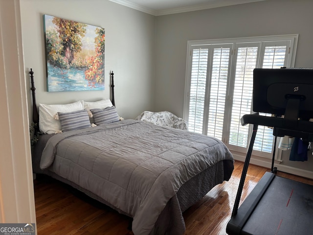 bedroom with crown molding and wood finished floors