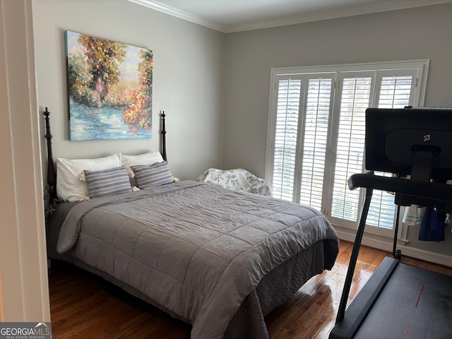 bedroom with crown molding and wood finished floors