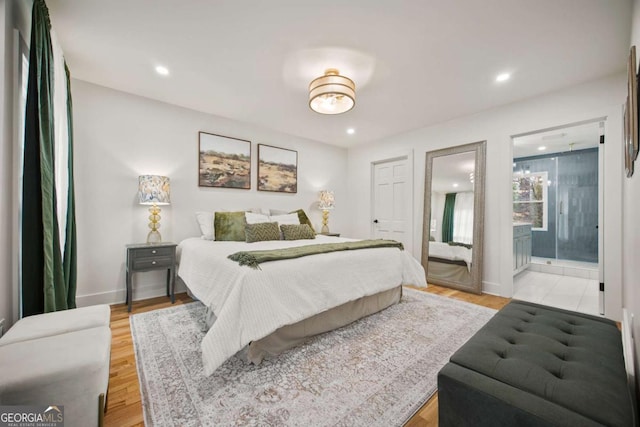 bedroom featuring ensuite bathroom and light wood-type flooring