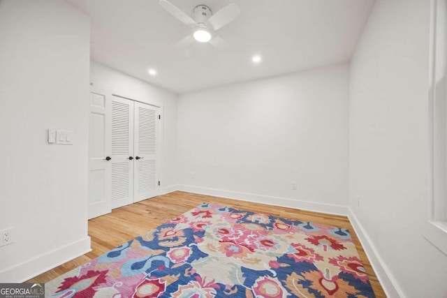 bedroom featuring hardwood / wood-style flooring, ceiling fan, and a closet