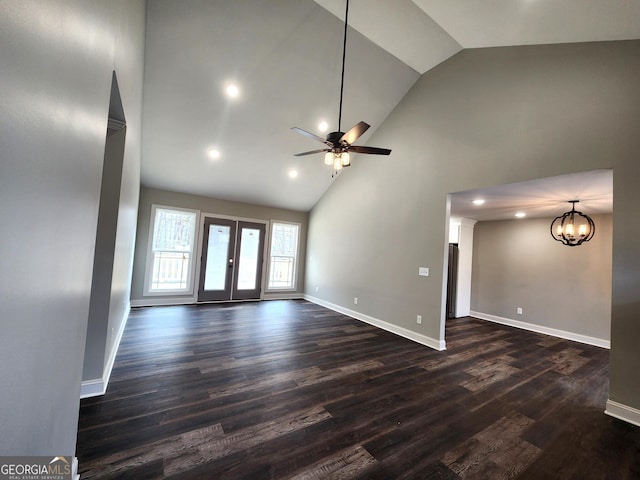 unfurnished living room with ceiling fan with notable chandelier, high vaulted ceiling, french doors, and dark hardwood / wood-style floors