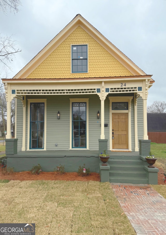 view of front of house featuring covered porch and a front lawn