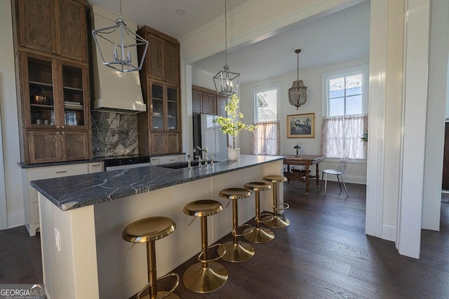 kitchen featuring dark hardwood / wood-style flooring, backsplash, oven, a kitchen breakfast bar, and pendant lighting