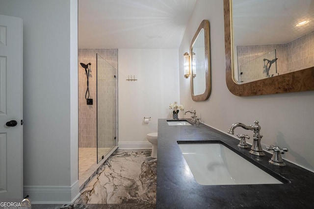 bathroom with tiled shower, vanity, and toilet