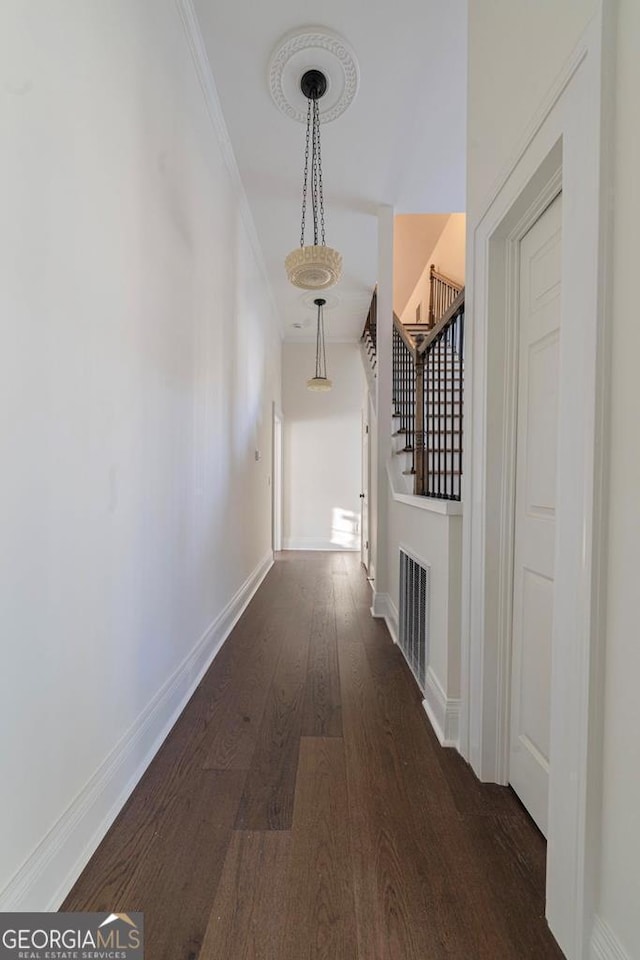 corridor featuring dark hardwood / wood-style flooring and ornamental molding