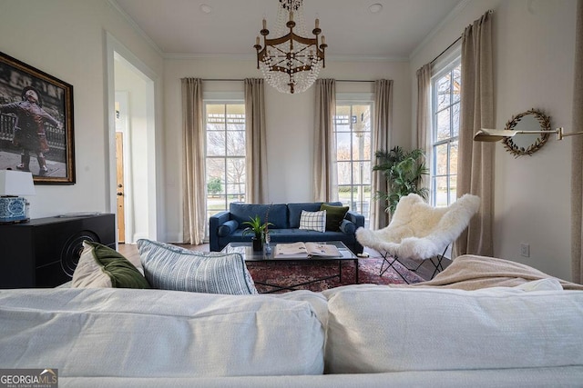 living room with a wealth of natural light, crown molding, and a notable chandelier