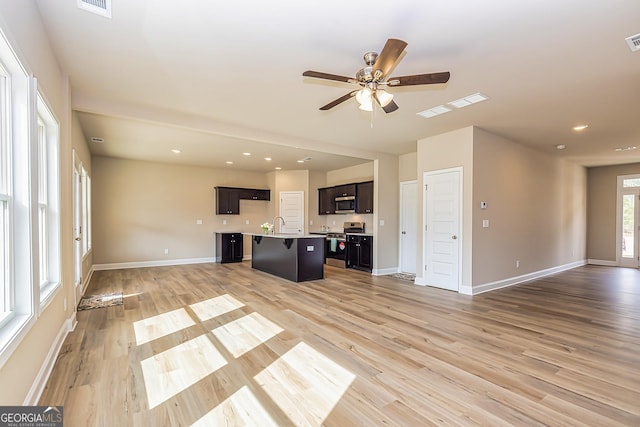 unfurnished living room featuring sink, ceiling fan, and light hardwood / wood-style flooring