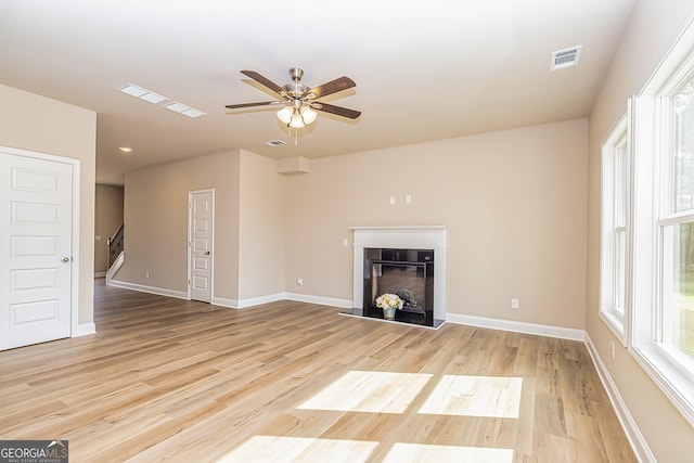 unfurnished living room with light wood-type flooring and ceiling fan