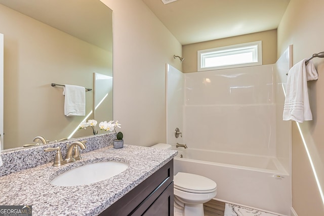 full bathroom featuring hardwood / wood-style floors, vanity, toilet, and washtub / shower combination