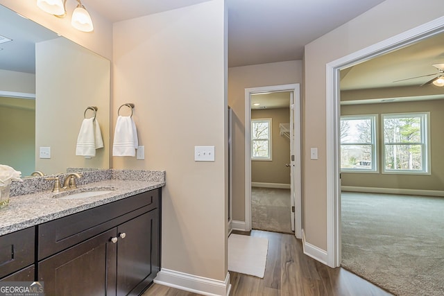 bathroom featuring vanity, ceiling fan, and wood-type flooring