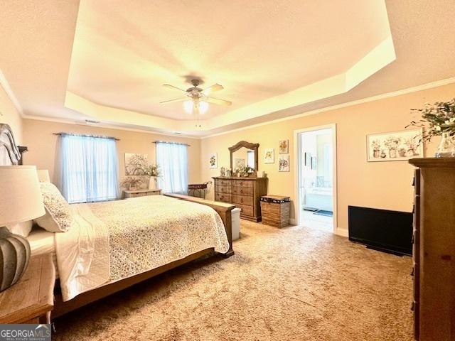 bedroom featuring carpet floors, ornamental molding, ceiling fan, and a raised ceiling