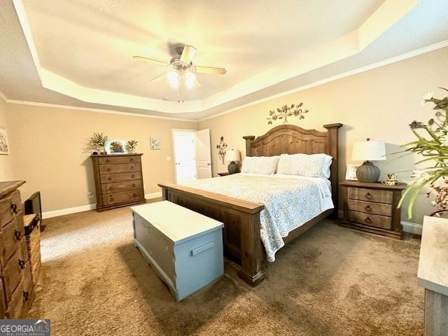 carpeted bedroom with ornamental molding, ceiling fan, and a raised ceiling