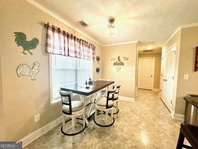 dining space with a textured ceiling and crown molding